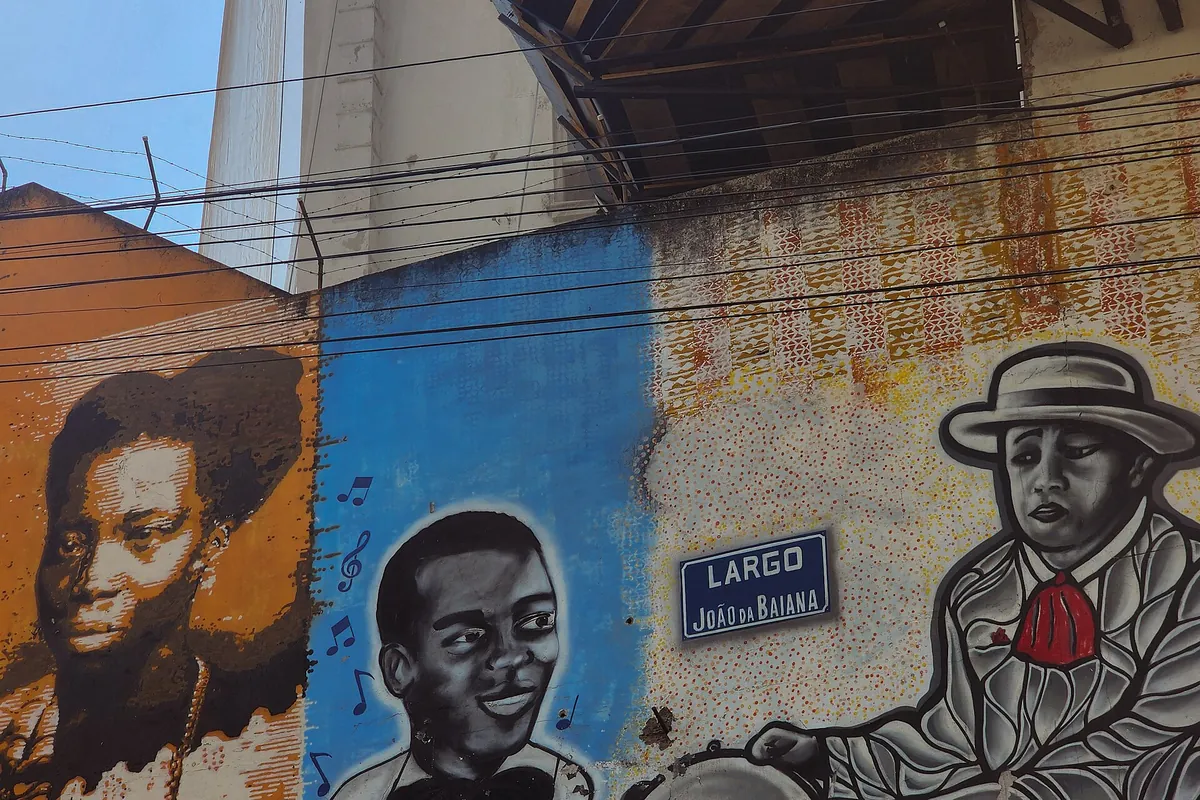 Painted murals at Pedra do Sal with three portraits and a street sign reading Largo João da Baiana