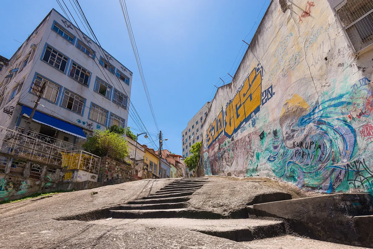 The carved granite steps of Pedra do Sal climbing the rock beside a wall covered in painted murals